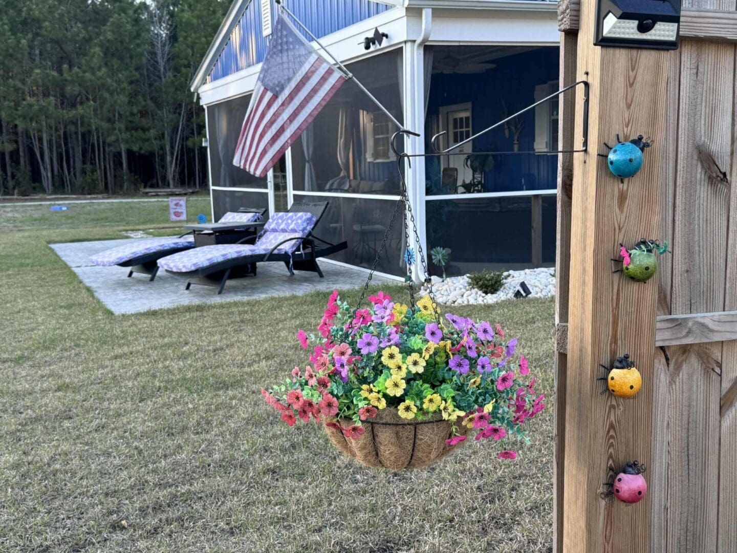 Basket of flowers by patio and flag.
