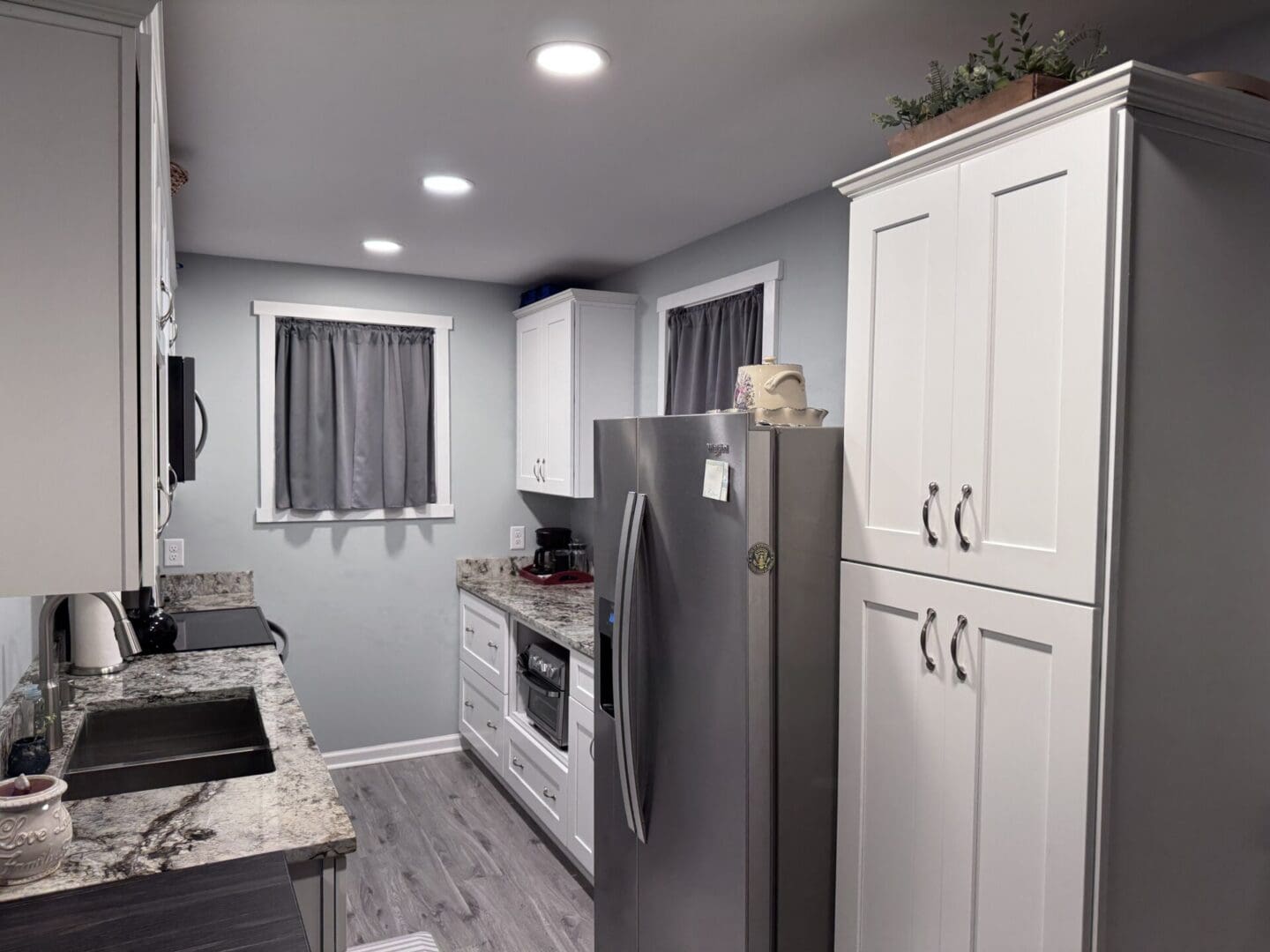 Modern kitchen with grey cabinets and appliances.