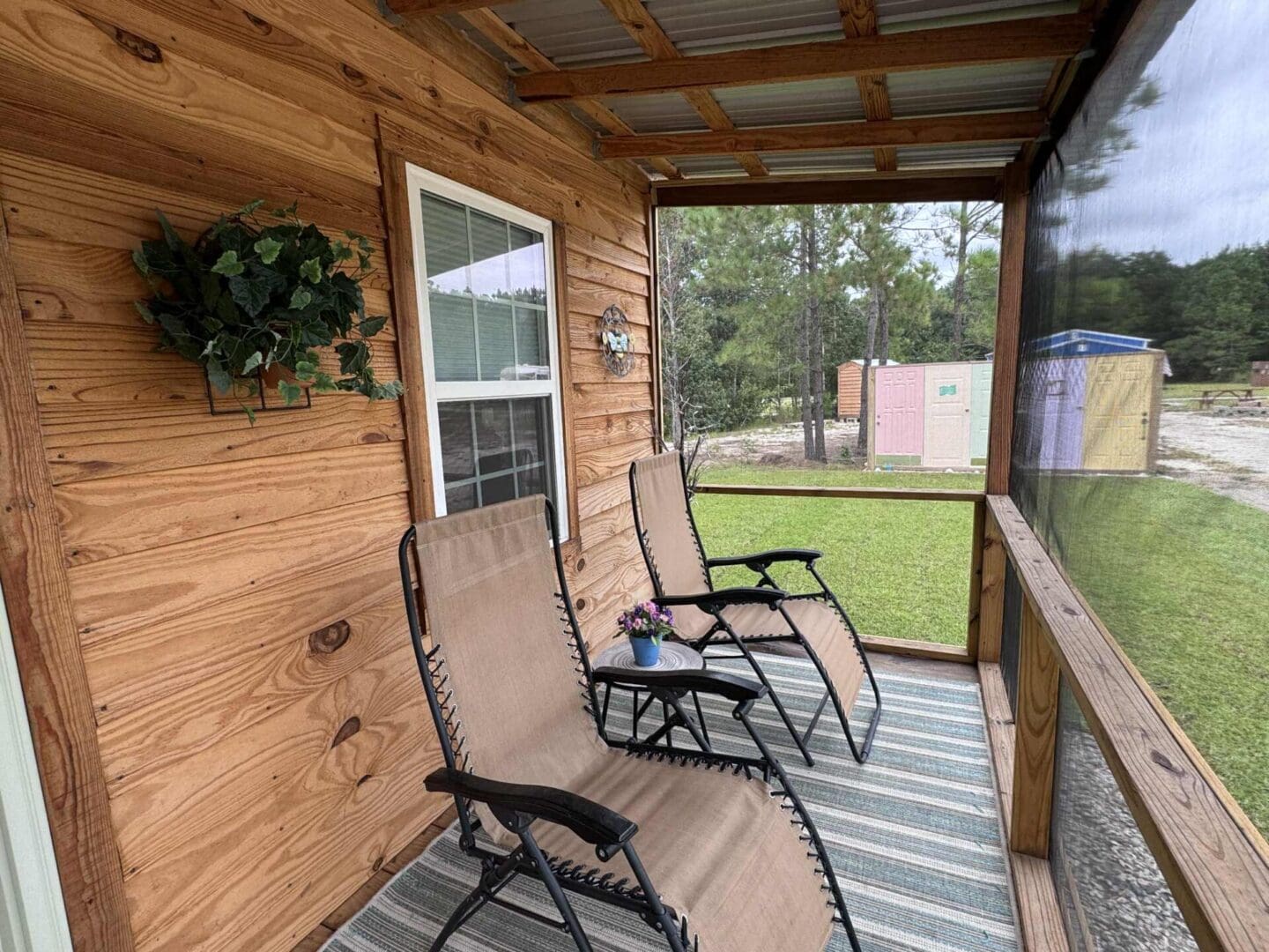 Two chairs on a screened wooden porch.