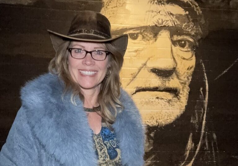 Jewel Leigh in front of the Willie Nelson mural in his hometown of Abbott, Texas